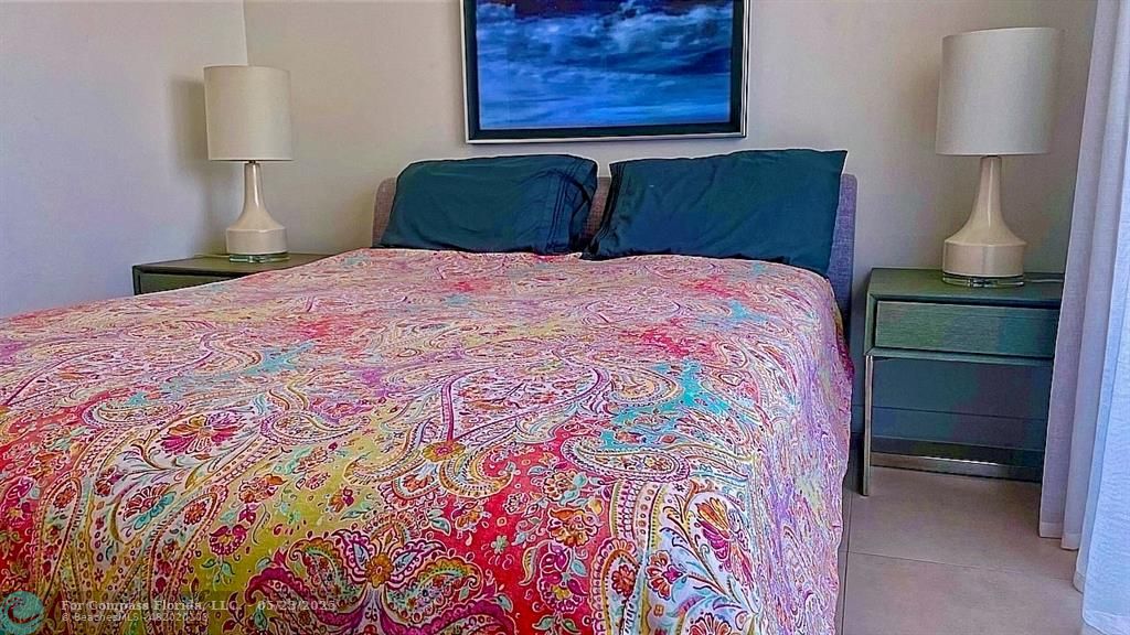 401 North Birch Road, Unit 415 Fort Lauderdale, FL 33304 - Photo 13 of 33 a bedroom with a bed and a lamp on dresser