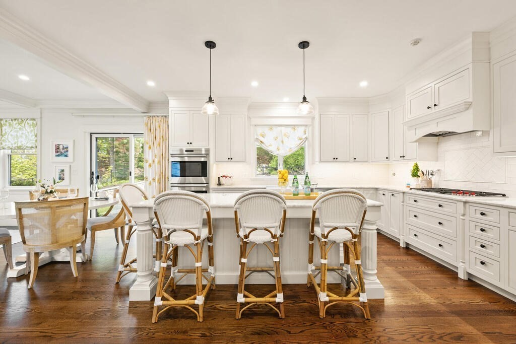 22 Richard Road Lexington, MA 02421 - Photo 14 of 42 a kitchen with stainless steel appliances kitchen island granite countertop a table chairs stove and white cabinets