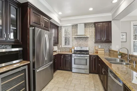 a kitchen with stainless steel appliances granite countertop a refrigerator stove and sink