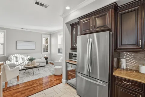 a kitchen with stainless steel appliances granite countertop a refrigerator and a stove top oven