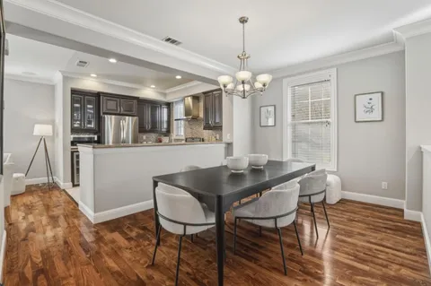 a view of a dining room with furniture a chandelier and wooden floor