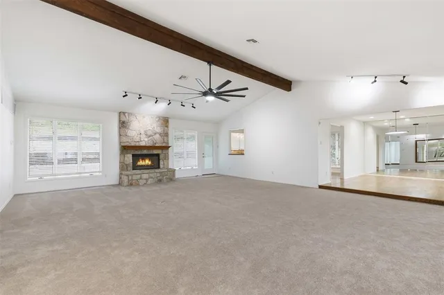 a view of an empty room with a fireplace and a window