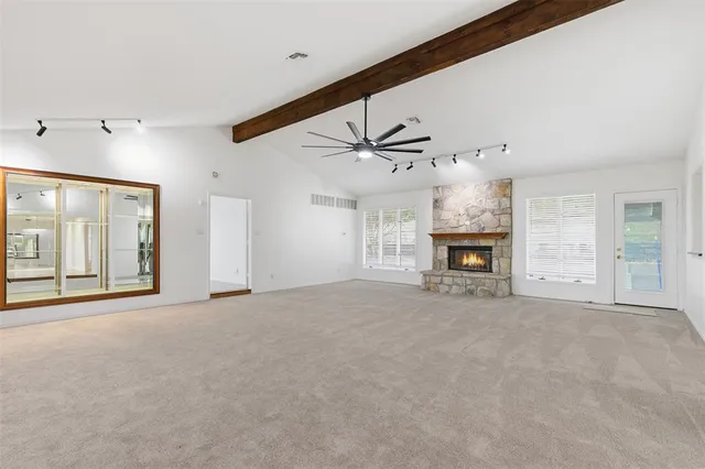 an empty room with fireplace and windows