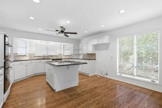 a kitchen with granite countertop a sink cabinets and wooden floor