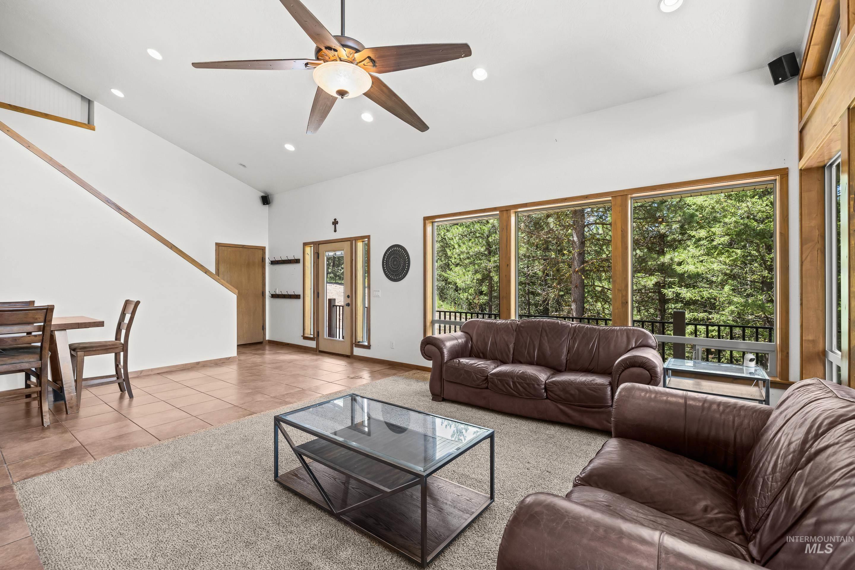 92 Cruickshank Road Horseshoe Bend, ID 83629 - Photo 14 of 50 Spacious living area featuring large windows with wood framing, recessed lighting, a ceiling fan, and a wood-finish staircase with a white wall