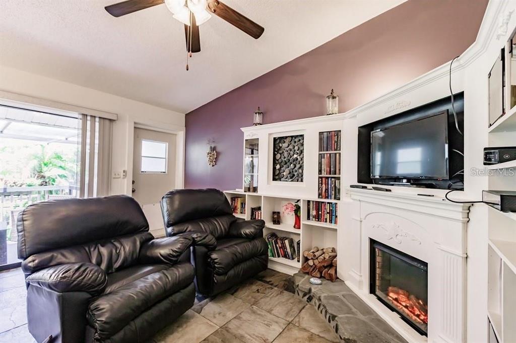 323 Bobby Jones Road, Unit 323 Sarasota, FL 34232 - Photo 6 of 10 a living room with furniture a flat screen tv and a fireplace