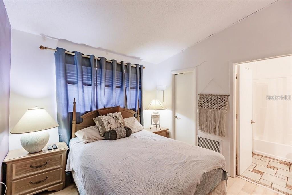 323 Bobby Jones Road, Unit 323 Sarasota, FL 34232 - Photo 9 of 10 a bedroom with a bed and wooden floor