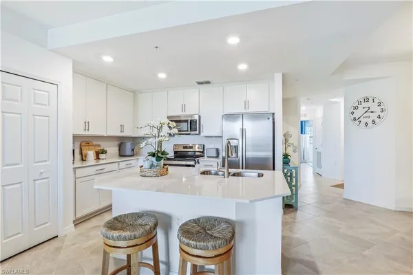 a kitchen with refrigerator and chairs