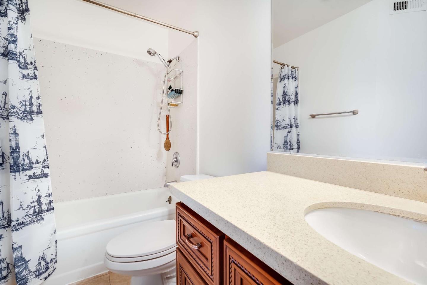 22135 Sevilla Road, Unit 47 Hayward, CA 94541 - Photo 16 of 37 a bathroom with a granite countertop sink a toilet a mirror a bathtub and shower