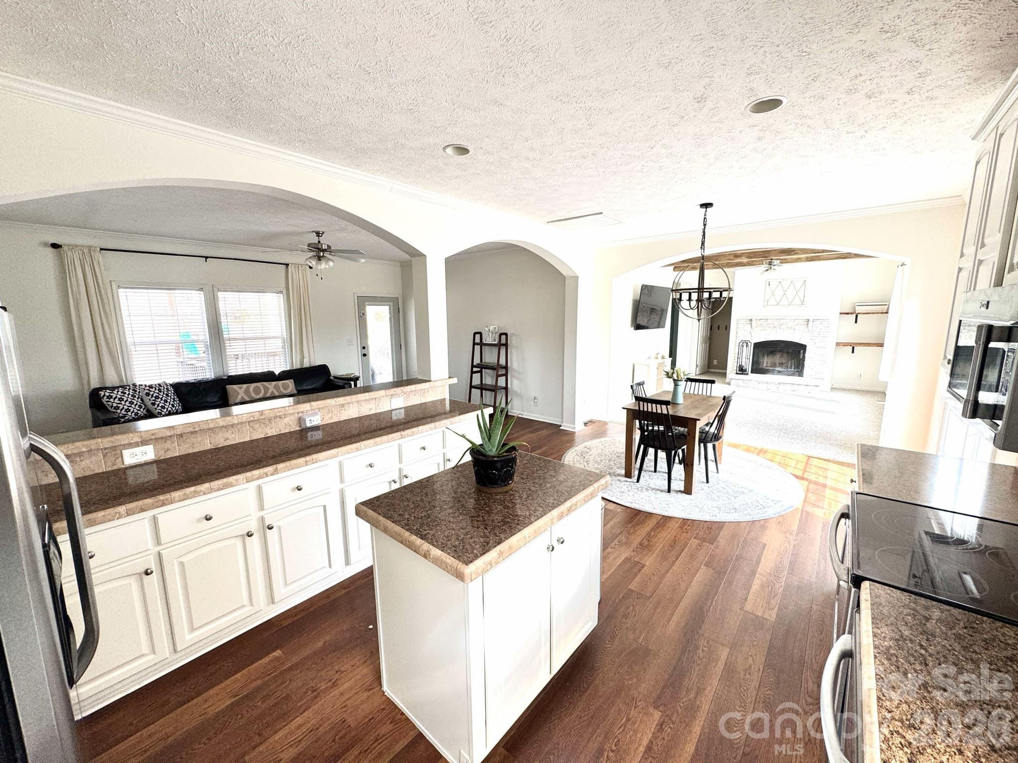 49428 Quail Trail Road Norwood, NC 28128 - Photo 3 of 13 a living room with stainless steel appliances kitchen island granite countertop wooden floor a dining table and chairs