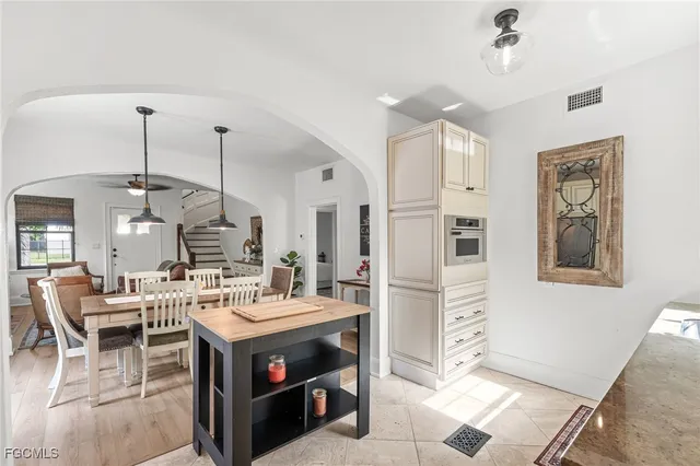 a large kitchen with a counter space a sink appliances and living room view