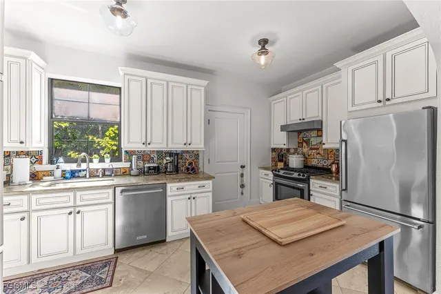 a kitchen with stainless steel appliances granite countertop a stove refrigerator sink and cabinets
