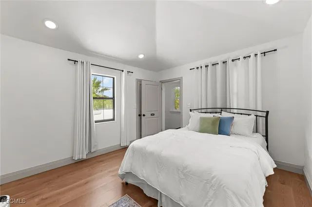 a bedroom with a large bed and wooden floor