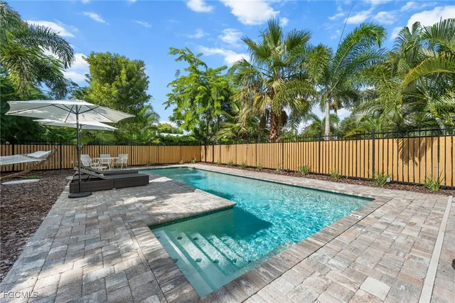 a view of a swimming pool with chairs in patio