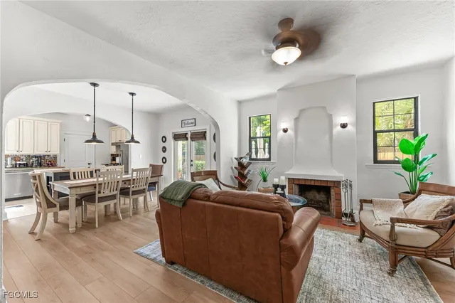 a living room with furniture a fireplace and a potted plant