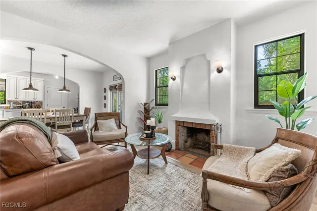 a living room with furniture fireplace and a large window