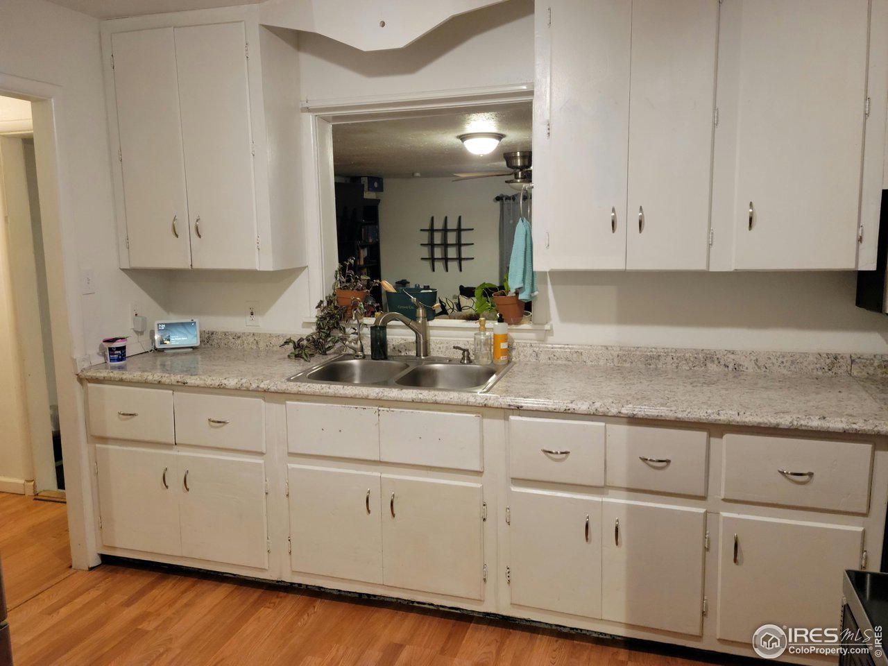 177 Delaware Drive Sterling, CO 80751 - Photo 3 of 13 a kitchen with granite countertop white cabinets and white appliances
