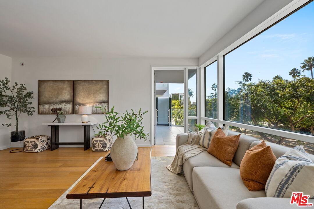 1705 Ocean Avenue, Unit 206 Santa Monica, CA 90401 - Photo 5 of 26 a living room with furniture potted plant and a large window