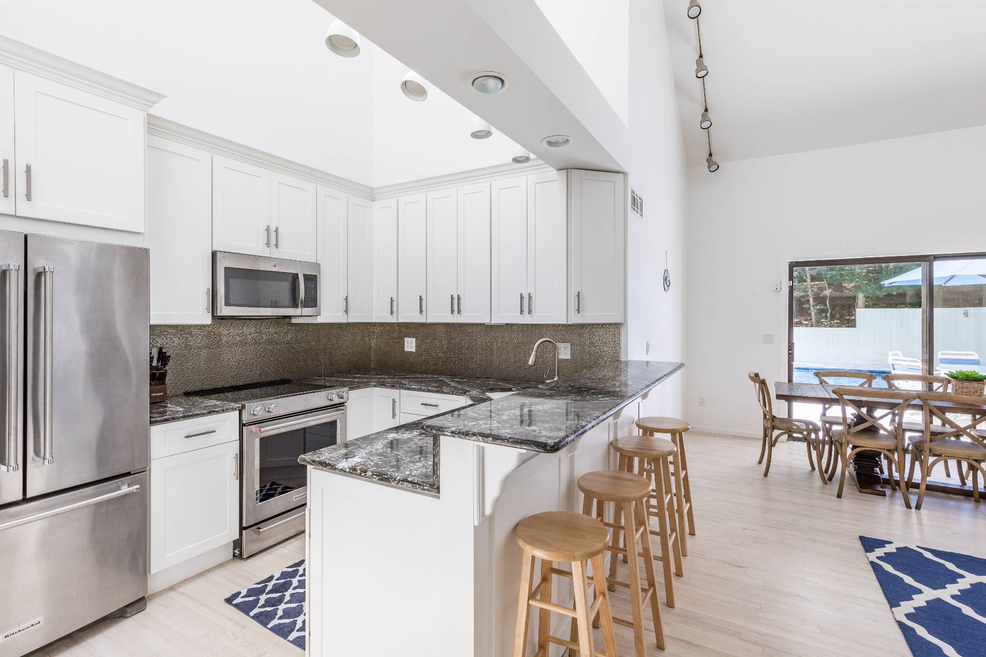 34 Rivers Road East Hampton, NY 11937 - Photo 7 of 17 a kitchen with a stove a sink dishwasher a refrigerator with a dining table and chairs