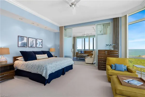 a spacious bedroom with a bed a couch and large windows