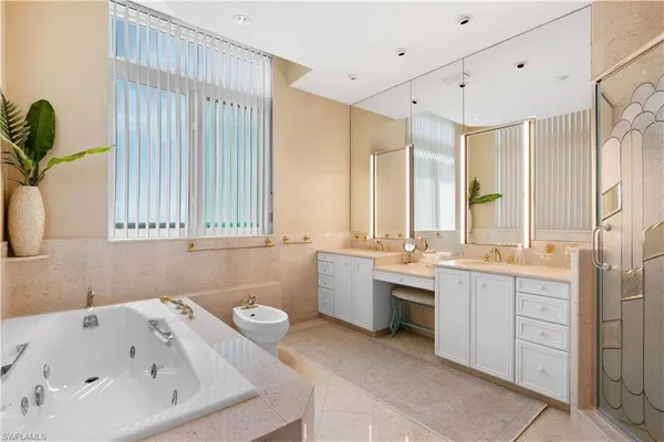 a bathroom with a tub sink and mirror