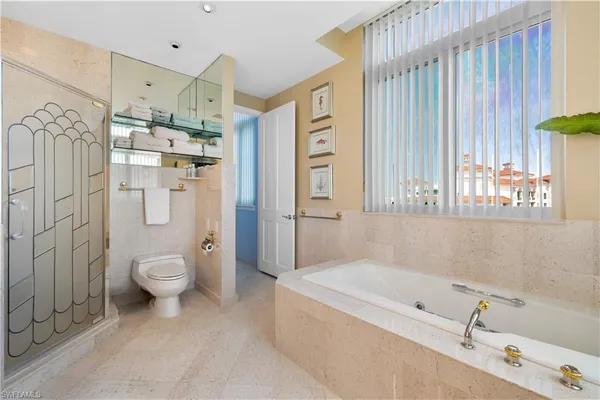 a bathroom with a granite countertop toilet a sink and a bathtub