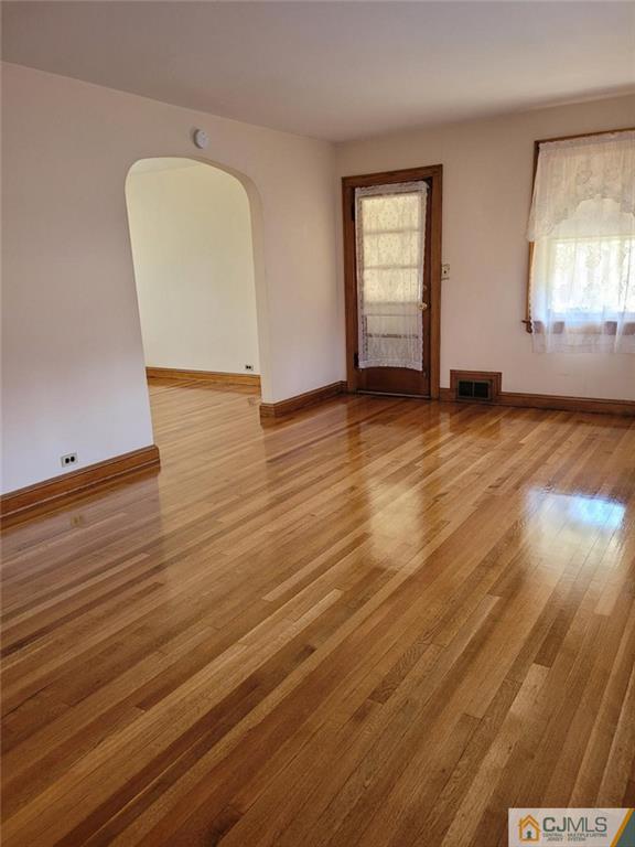 9 Carpender Road New Brunswick, NJ 08901 - Photo 5 of 15 an empty room with wooden floor and windows