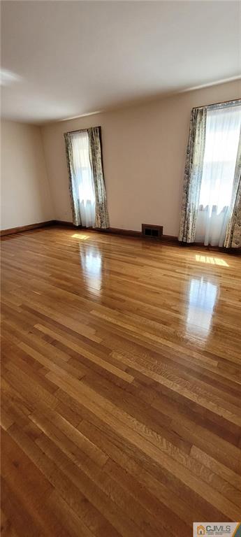 9 Carpender Road New Brunswick, NJ 08901 - Photo 6 of 15 an empty room with wooden floor and windows