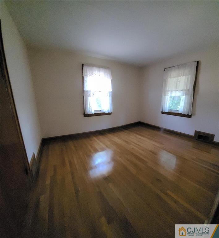 9 Carpender Road New Brunswick, NJ 08901 - Photo 8 of 15 an empty room with wooden floor and windows