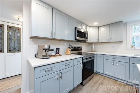 a kitchen with white cabinets sink and stainless steel appliances