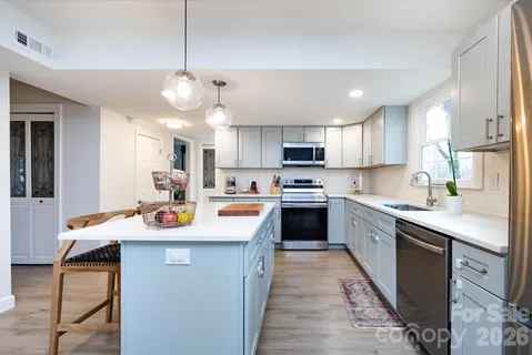 a kitchen with stainless steel appliances granite countertop a sink a stove and a refrigerator