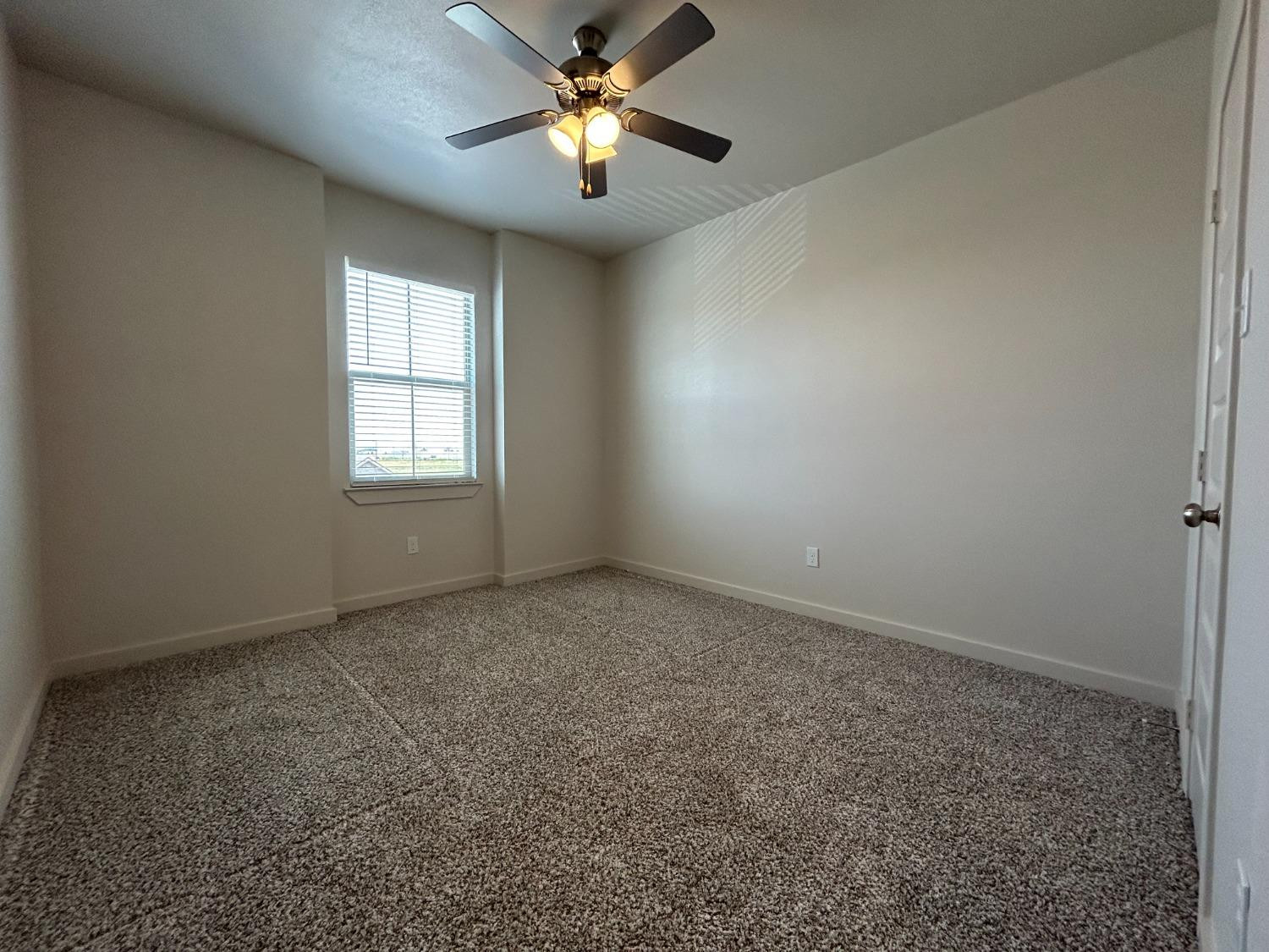 2603 135th Street Lubbock, TX 79423 - Photo 7 of 12 an empty room with windows and fan