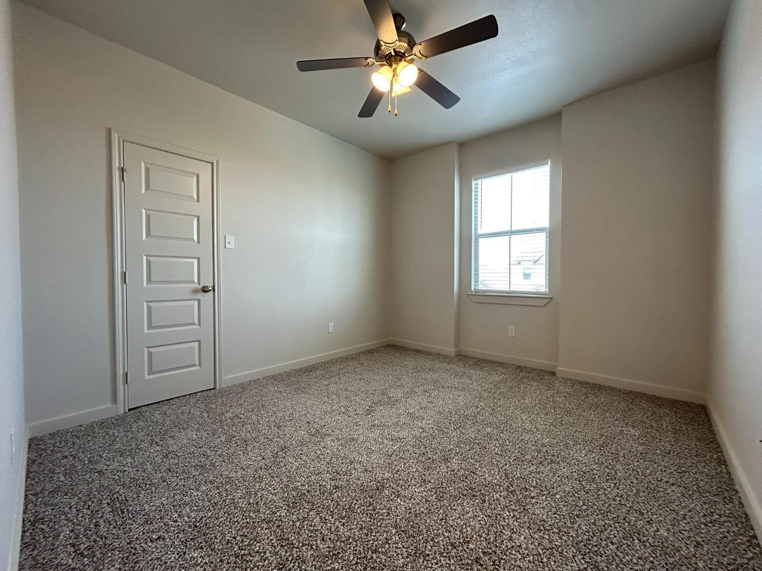 2603 135th Street Lubbock, TX 79423 - Photo 9 of 12 an empty room with windows and fan