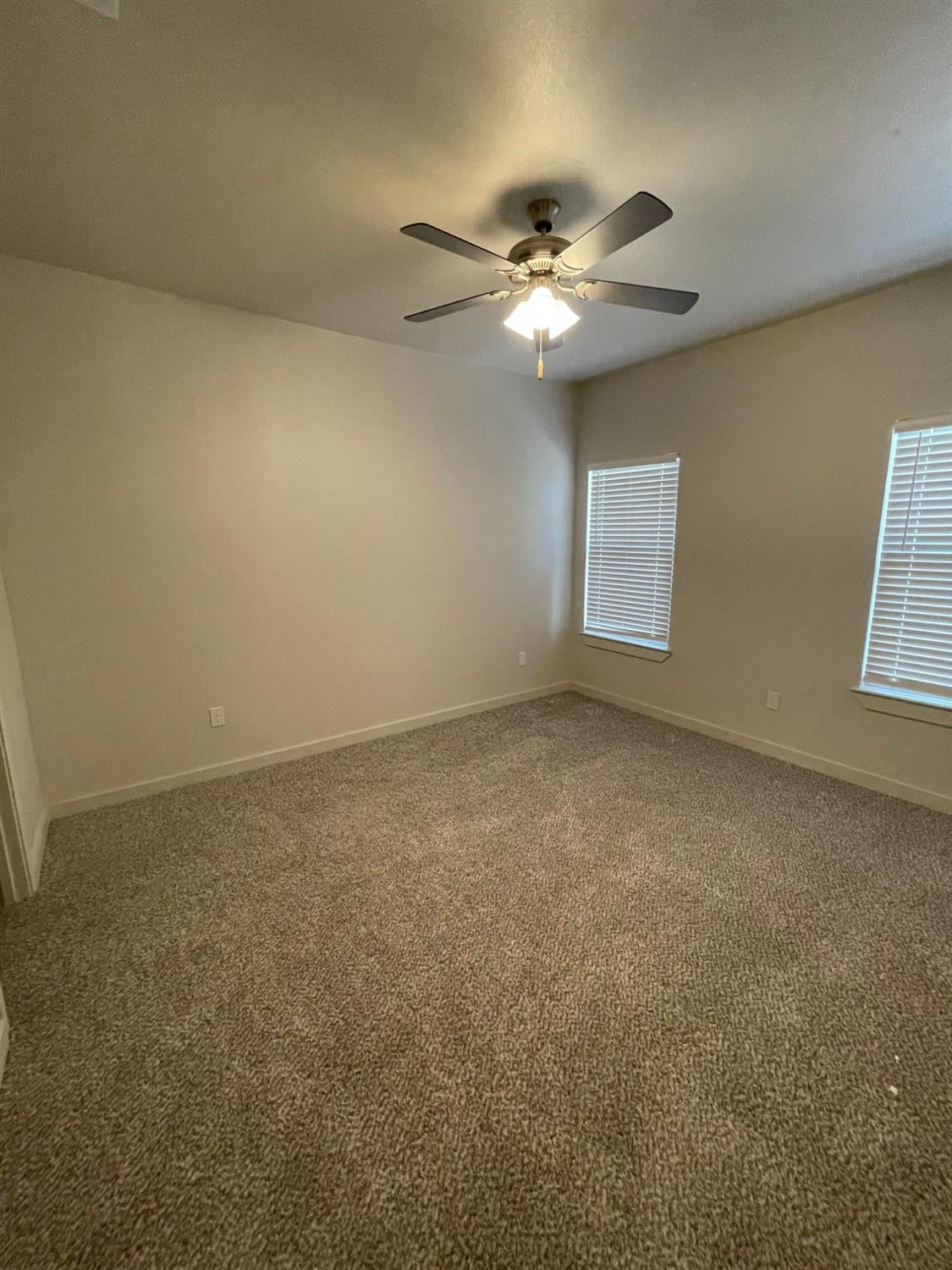 2603 135th Street Lubbock, TX 79423 - Photo 10 of 12 an empty room with windows and fan