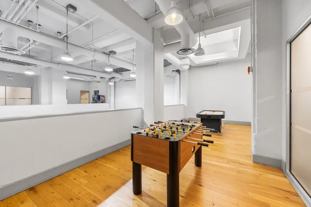 a view of a kitchen with kitchen island stainless steel appliances a stove a sink dishwasher and a dining table with wooden floor