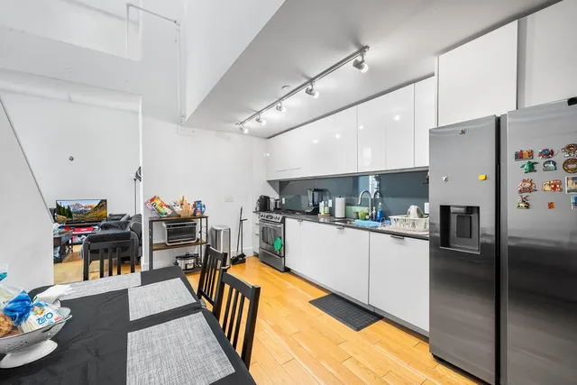 a kitchen with stainless steel appliances kitchen island granite countertop a refrigerator and stove top oven