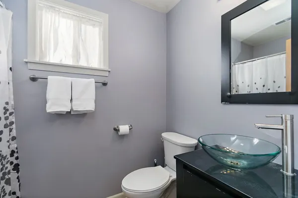 a bathroom with a toilet a sink and mirror