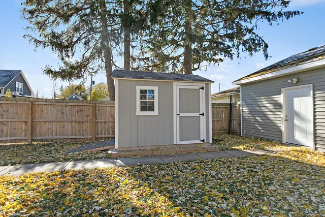 a view of a house with a small yard and large tree