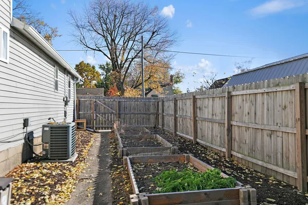 a view of a backyard with wooden fence and a large tree