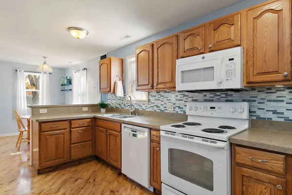 a kitchen with stainless steel appliances granite countertop a stove a sink and a microwave