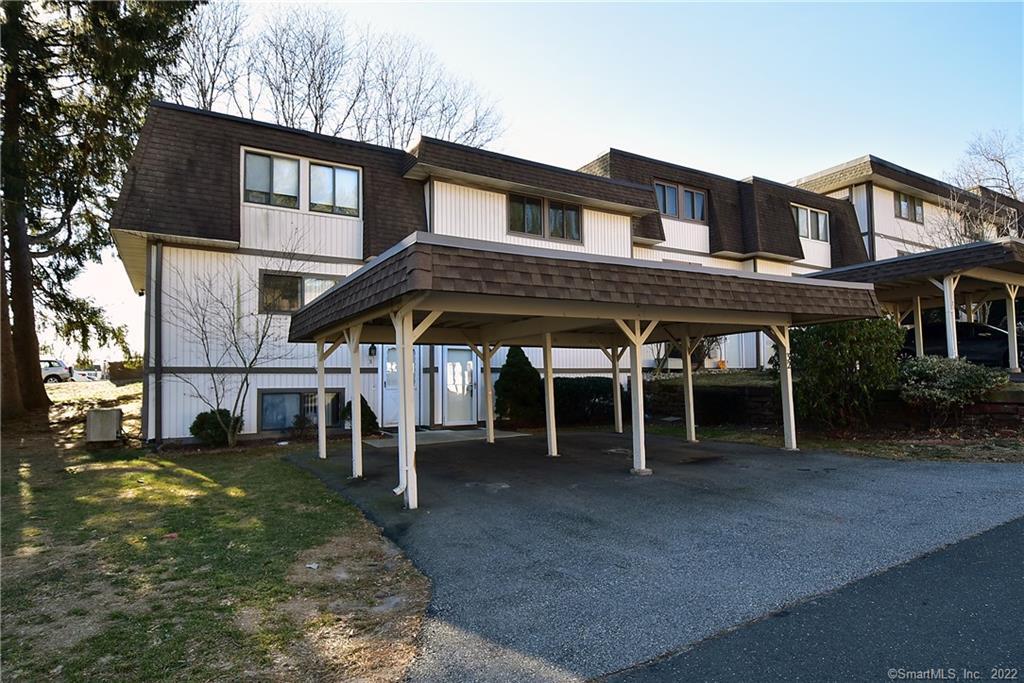 32 Shad Row, Unit 32 Suffield, CT 06078 - Photo 1 of 1 #32 entry door to right with carport. Additional assigned parking spot near unit