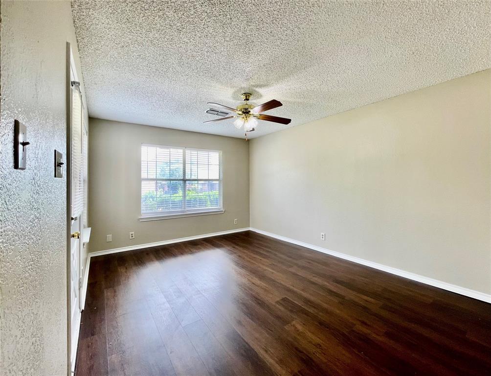 524 Strata Drive Denton, TX 76201 - Photo 4 of 17 an empty room with wooden floor fan and windows