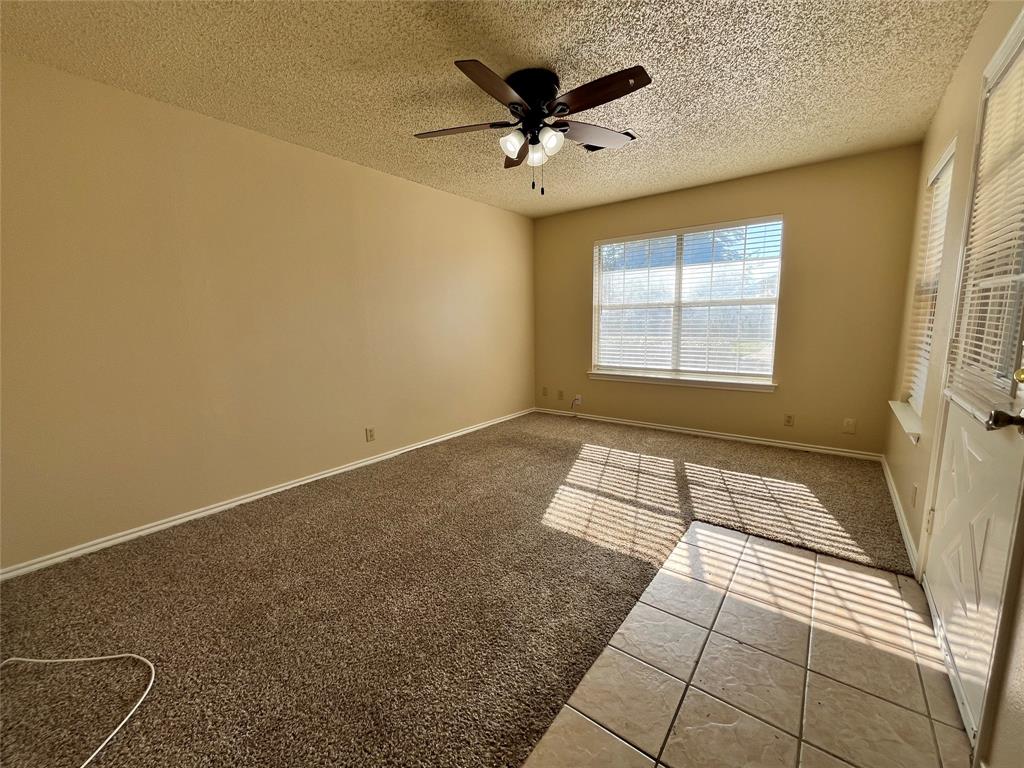 524 Strata Drive Denton, TX 76201 - Photo 5 of 17 Notice the lighted ceiling fan, access to the outside, carpet and tile combination, and 2 sizable windows that let in natural lighting.