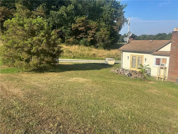 a view of yard and swimming pool with green space