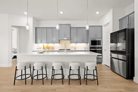 a kitchen with granite countertop a refrigerator stove microwave and cabinets