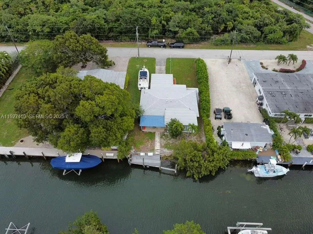 an aerial view of a house with swimming pool patio and lake view