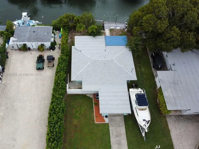 an aerial view of a house with outdoor space and a lake view