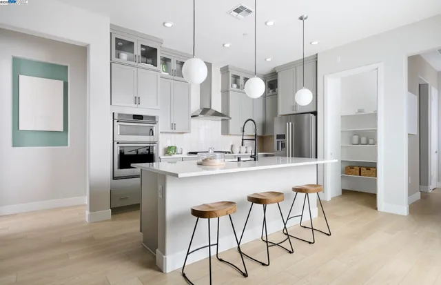 a kitchen with stainless steel appliances a stove a sink island and a refrigerator