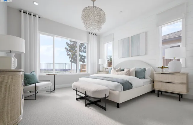 a spacious bedroom with a bed and a chandelier