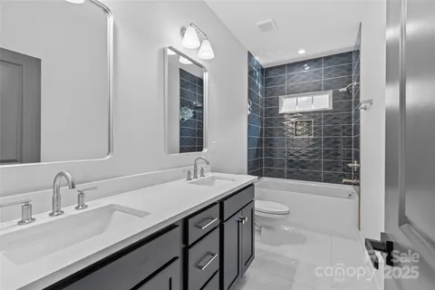 a bathroom with a double vanity sink toilet mirror and bathtub